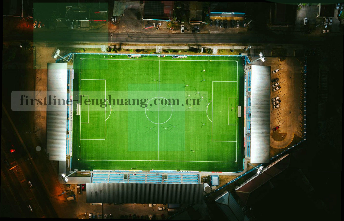 夜间办公区屏幕上显示的赛程数据表格与色块图表，侧逆光构图